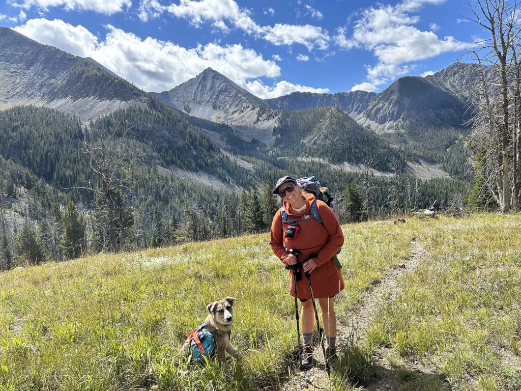 Hiker and her dog pausing on a forest trail