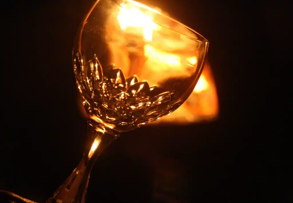 Glass glowing in warm firelight, setting a romantic mood