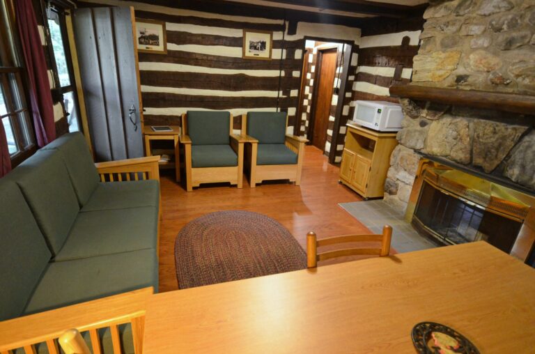 Welcoming cabin living room with sofa, rocking chairs and a stone fireplace